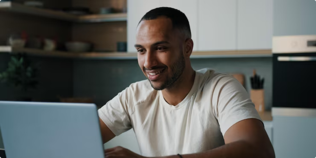 Homem sorrindo usando laptop